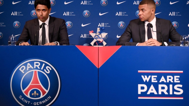 (FILES) Paris Saint-Germain's CEO Nasser Al-Khelaifi (L) and French forward Kylian Mbappe (R) give a press conference at the Parc des Princes stadium in Paris on May 23, 2022, two days after the club won the Ligue 1 title for a record-equalling tenth time and its superstar striker Mbappe chose to sign a new contract at PSG rather than join Real Madrid. French champions Paris Saint-Germain have left Kylian Mbappe out of their squad for a pre-season tour of Japan, casting further doubt on the star striker's future. Mbappe declared in May 2023 that he would not extend his PSG contract, which expires next year, but indicated he wanted to remain at the club for a final season. (Photo by FRANCK FIFE / AFP)