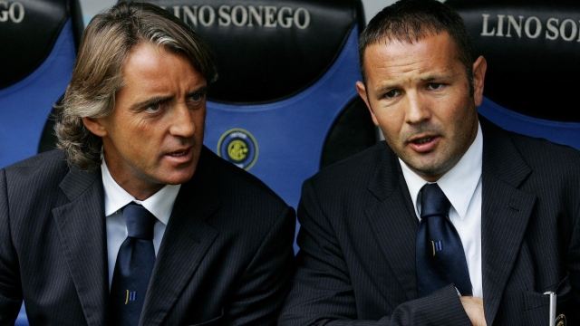 (FILES) In this file photo taken on September 24, 2006 Inter Milan's coach Roberto Mancini (L) speaks with his assistant coach Sinisa Mihajlovic before their Serie A football match against Chievo Verona at San Siro stadium in Milan. - Former Serbia international-turned-coach Sinisa Mihajlovic has died of leukemia at the age of 53, his family said in a statement on December 16, 2022. (Photo by PACO SERINELLI / AFP)