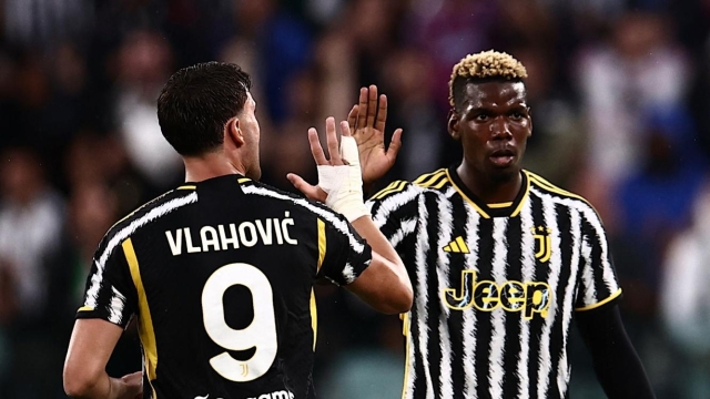 Juventus Serbian forward Dusan Vlahovic (L) celebrates with teammate Juventus French midfielder Paul Pogba (R) after scoring during the Italian Serie A football match Juventus vs Bologna on August 27, 2023 at the Allianz Stadium in Turin. (Photo by MARCO BERTORELLO / AFP)