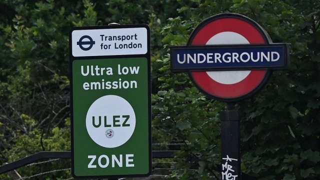 Cars pass a sign indicating the ultra-low emission zone (ULEZ) at Hanger Lane in west London on July 22, 2023. Sadiq Khan intends to expand the Ultra-Low Emission Zone (ULEZ) to the whole of the British capital on August 29 -- barring a last-ditch High Court bid to stop it. The scheme -- first introduced in inner London in 2019 and separate from its two-decades-old congestion charge -- requires more polluting vehicles to pay a £12.50 ($16) toll on days they are driven within its borders. (Photo by JUSTIN TALLIS / AFP)