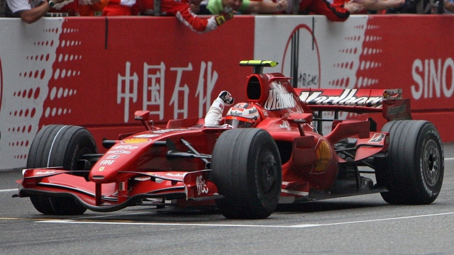 Finnish driver Kimi Raikkonen from the Ferrari team celebrates after crossing the finish line and winning the Formula One Chinese Grand Prix at the Shanghai International Circuit, 07 October 2007. Formula One's world championship was blown wide open after Lewis Hamilton dramatically slid into a gravel trap in the Chinese Grand Prix and Kimi Raikkonen snatched victory for Ferrari.   AFP PHOTO/Mark RALSTON
