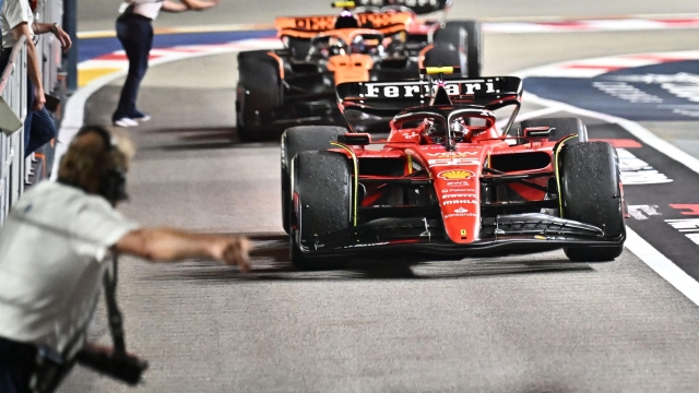 Ferrari's Spanish driver Carlos Sainz Jr (front) drives after winning the Singapore Formula One Grand Prix night race in front of McLaren's British driver Lando Norris (centre) and Mercedes' British driver Lewis Hamilton (back) at the Marina Bay Street Circuit in Singapore on September 17, 2023. (Photo by Lillian SUWANRUMPHA / AFP)