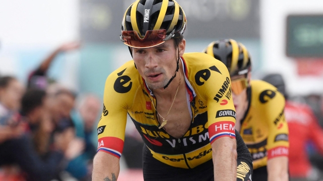 TOPSHOT - Team Jumbo's Slovenian rider Primoz Roglic crosses the finish line in first place followed by Team Jumbo-Visma's Danish rider Jonas Vingegaard during the stage 17 of the 2023 La Vuelta cycling tour of Spain, a 124,4 km race between Ribadesella and Alto de l'Angliru on September 13, 2023. (Photo by MIGUEL RIOPA / AFP)