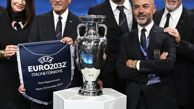 Head of Italian delegation and Italian former professional football player Gianluigi Buffon (3rdR), Italian TV host and commentator Ilaria D'Amico (L), President of the Italian Football Federation (FIGC) Gabriele Gravina (2ndL) and CEO of the Italian professional Football League Marco Brunelli (2ndR) pose with the trophy and the pennant after Italy was elected to host the Euro 2032 fooball tournament during the announcement ceremony at the UEFA headquarters in Nyon on October 10, 2023. (Photo by Fabrice COFFRINI / AFP)