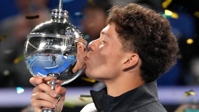 epa10932382 Ben Shelton of the United States kisses the winner's trophy after defeating Aslan Karatsev of Russia to win the men's singles final of the Japan Open Tennis Championships in Tokyo, Japan, 22 October 2023.  EPA/KIMIMASA MAYAMA