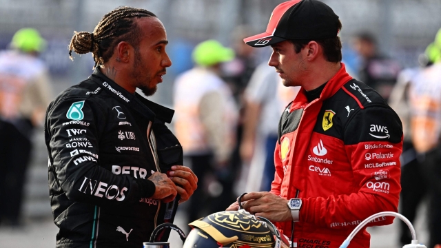 (FILES) Mercedes' British driver Lewis Hamilton (L) speaks with Ferrari's Monegasque driver Charles Leclerc after the Sprint race at the Circuit of the Americas in Austin, Texas, on October 21, 2023 ahead of the United States Formula One Grand Prix. Mercedes star Lewis Hamilton and Ferrari's Charles Leclerc were both disqualified from Sunday's October 22 US Grand Prix after their cars failed post-race inspections. Former world champion Hamilton had finished second behind Max Verstappen in Austin while Leclerc came in sixth. Both drivers saw those results scratched, however, after a technical team found excessive wear of their cars floor planks. (Photo by Chandan Khanna / AFP)