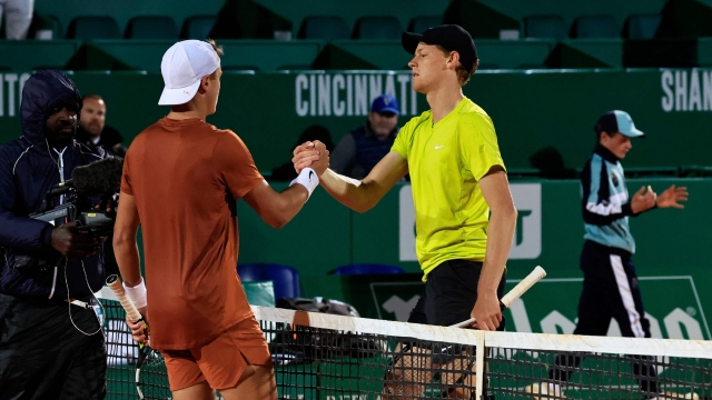 Denmark's Holger Rune (L) shakes hands with Italy's Jannik Sinner after winning the Monte-Carlo ATP Masters Series tournament semi-final tennis match against Italy's Jannik Sinner in Monte Carlo, on April 15, 2023. (Photo by Valery HACHE / AFP)