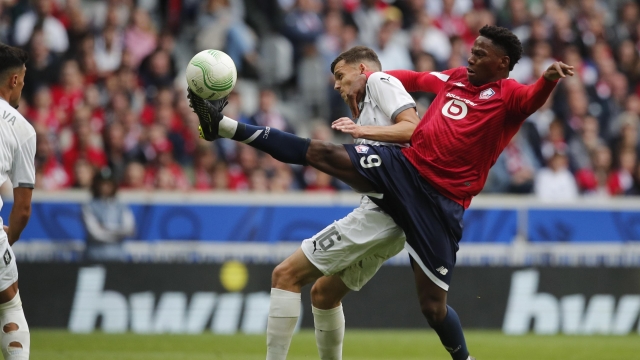 Olimpija's Ahmet Muhamedbegovic and Lille's Jonathan David, right, battle for the ball during the Conference League soccer match between Lille and NK Olimpija Ljubljana, Wednesday, Sept 20, 2023, at the Pierre Mauroy stadium in Villeneuve-d'Ascq, outside Lille northern France. (AP Photo/Michel Spingler)