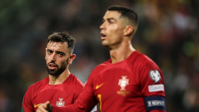 Portugal's midfielder #08 Bruno Fernandes (L) speaks with Portugal's forward #07 Cristiano Ronaldo during the UEFA Euro 2024 group J qualifying football match between Portugal and Iceland at the Jose Alvalade stadium in Lisbon on November 19, 2023. (Photo by PATRICIA DE MELO MOREIRA / AFP)