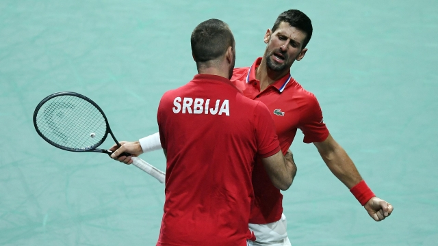 Serbia's Novak Djokovic celebrates beating Britain's Cameron Norrie with Serbia's captain Viktor Troicki (L) after winning the second men's doubles quarter-final tennis match between Serbia and Great Britain of the Davis Cup tennis tournament at the Martin Carpena sportshall, in Malaga on November 23, 2023. (Photo by JORGE GUERRERO / AFP)