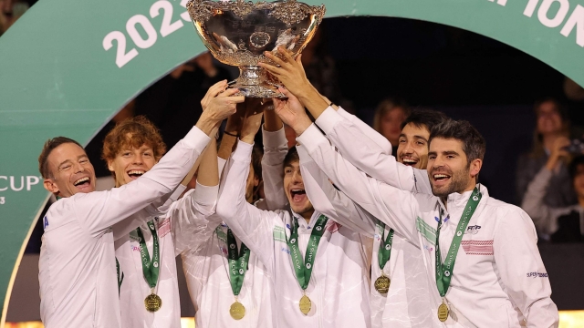 TOPSHOT - The members of team Italy raise their trophy as they celebrate winning the Davis Cup tennis tournament at the Martin Carpena sportshall, in Malaga on November 26, 2023. (Photo by LLUIS GENE / AFP)