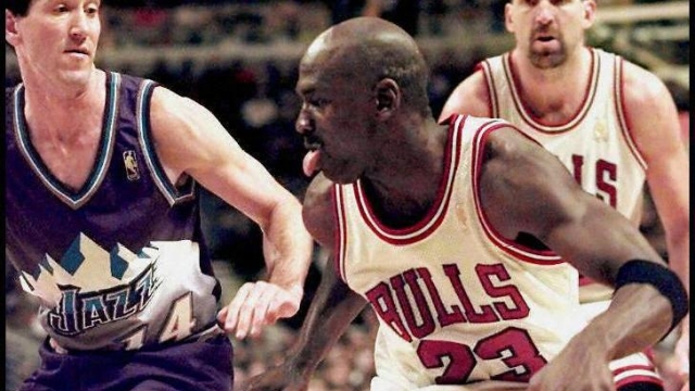 Michael Jordan (C) of the Chicago Bulls tries to drive past Jeff Hornacek of the Utah Jazz (L) 06 January during the second half of their game at the United Center in Chicago, Illinois. The Bulls won the game 102-89.  (ELECTRONIC IMAGE) (Photo by JEFF HAYNES / AFP)
