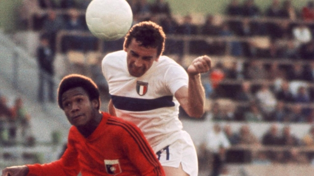(FILES) Italian forward Luigi "Gigi" Riva (R) jumps over Haitian defender Arsene Auguste as he heads the ball during the World Cup first round match between Italy and Haiti on June 15, 1974 in Munich. Sardinia was mourning the loss of a sporting deity on January 22, 2024 after the death of former Italy striker Luigi "Gigi" Riva, who did more than anyone else to put the Italian island on the footballing map. (Photo by STAFF / AFP)