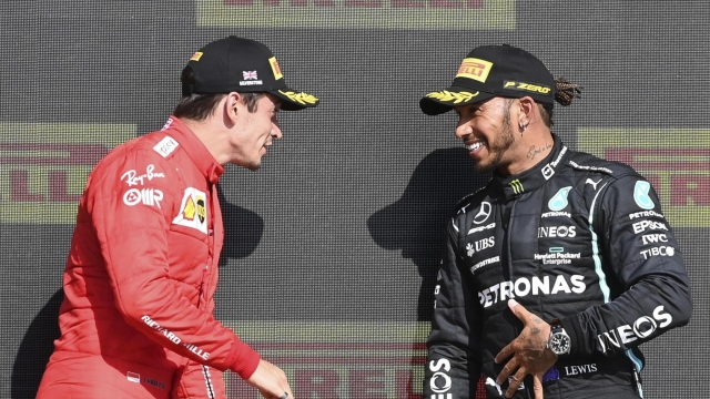 epa09352370 Winner British Formula One driver Lewis Hamilton (R) of Mercedes-AMG Petronas and second placed Monaco's Formula One driver Charles Leclerc of Scuderia Ferrari Mission Winnow react on the podium after the Formula One Grand Prix of Great Britain at the Silverstone Circuit, in Northamptonshire, Britain, 18 July 2021.  EPA/ANDY RAIN