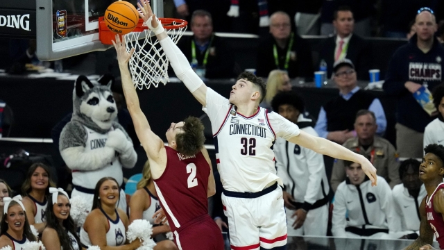 Alabama forward Grant Nelson (2) shoots past UConn center Donovan Clingan during the first half of the NCAA college basketball game at the Final Four, Saturday, April 6, 2024, in Glendale, Ariz. (AP Photo/Ross D. Franklin)