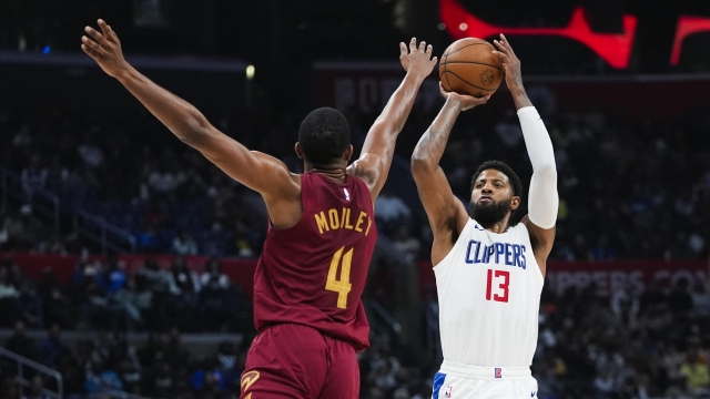 Los Angeles Clippers forward Paul George, right, shoots past Cleveland Cavaliers forward Evan Mobley (4) during the second half of an NBA basketball game, Sunday, April 7, 2024, in Los Angeles. (AP Photo/Ryan Sun)