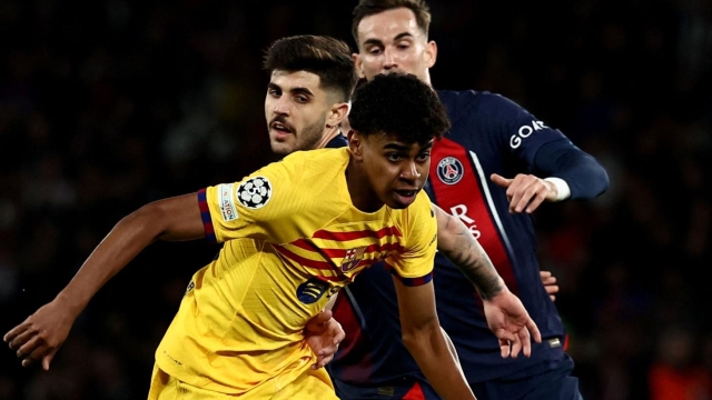 Barcelona's Spanish forward #27 Lamine Yamal runs with the ball during the UEFA Champions League quarter final first leg football match between Paris Saint-Germain (PSG) and FC Barcelona at the Parc des Princes stadium in Paris on April 10, 2024. (Photo by Anne-Christine POUJOULAT / AFP)