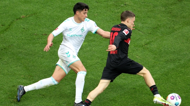 LEVERKUSEN, GERMANY - APRIL 14: Florian Wirtz of Bayer Leverkusen runs with the ball whilst under pressure from Julian Malatini of SV Werder Bremen during the Bundesliga match between Bayer 04 Leverkusen and SV Werder Bremen at BayArena on April 14, 2024 in Leverkusen, Germany. (Photo by Andreas Rentz/Getty Images)