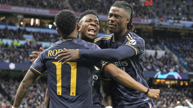 Real Madrid's Vinicius Junior, center, celebrates after his teammate Real Madrid's Rodrygo, left, scored his side's opening goal during the Champions League quarterfinal second leg soccer match between Manchester City and Real Madrid at the Etihad Stadium in Manchester, England, Wednesday, April 17, 2024. (AP Photo/Dave Shopland)