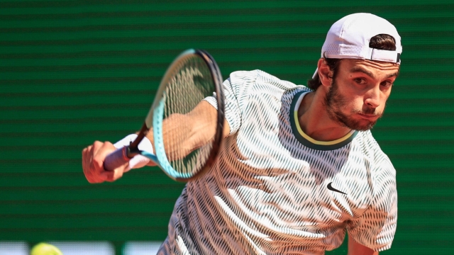 Italy's Lorenzo Musetti plays a backhand return to Serbia's Novak Djokovic during their Monte Carlo ATP Masters Series Tournament round of 16 tennis match on the Rainier III court at the Monte Carlo Country Club on April 11, 2024. (Photo by Valery HACHE / AFP)
