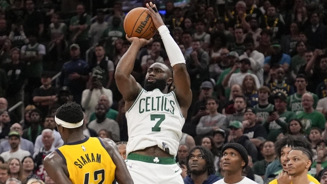 Boston Celtics guard Jaylen Brown (7) puts up a 3-point shot to score and tie the game against the Indiana Pacers with seconds left in Game 1 of the NBA Eastern Conference basketball finals, Tuesday, May 21, 2024, in Boston. (AP Photo/Charles Krupa)