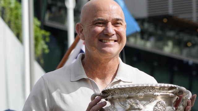 FILE - Former Grand Slam champion Andre Agassi poses with the men's Norman Brookes Challenge Cup trophy ahead of the start of the Australian Open tennis championships at Melbourne Park in Melbourne, Australia, Sunday, Jan. 14, 2024. Agassi will take over from John McEnroe as the captain for Team World at the Laver Cup next year, when the event will be held in San Francisco. Laver Cup organizers announced Agassi's selection on Wednesday, May 22, and said Bjorn Borg's successor as captain of Team Europe will be named ?in the coming days.?  (AP Photo/Andy Wong, File)