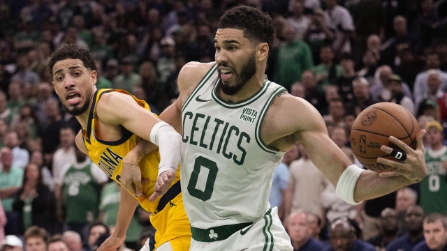Boston Celtics forward Jayson Tatum (0) controls a rebound against Indiana Pacers guard Tyrese Haliburton (0) in overtime of Game 1 of the NBA Eastern Conference basketball finals, Tuesday, May 21, 2024, in Boston. (AP Photo/Charles Krupa)