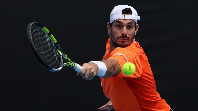 MELBOURNE, AUSTRALIA - JANUARY 18: Giulio Zeppieri of Italy plays a backhand in their round two singles match against Cameron Norrie of Great Britain during the 2024 Australian Open at Melbourne Park on January 18, 2024 in Melbourne, Australia. (Photo by Julian Finney/Getty Images)
