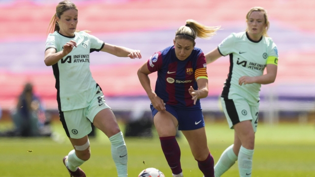 epa11290004 FC Barcelona's player Alexia Putellas (C) vies for the ball against Chelsea's Melanie Leupolz (L) during the UEFA Women's Champions League semifinal, first leg match between FC Barcelona and Chelsea FC held at Lluis Companys Olympic Stadium in Barcelona, Spain, 20 April 2024.  EPA/Enric Fontcuberta