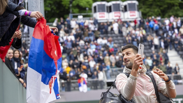 epa11364067 Novak Djokovic of Serbia takes a selfie for a spectator with a Serbian flag after winning his singles quarter-final match against Tallon Griekspoor of Netherlands, at the ATP 250 Geneva Open tennis tournament, in Geneva, Switzerland, 23 May 2024.  EPA/MARTIAL TREZZINI