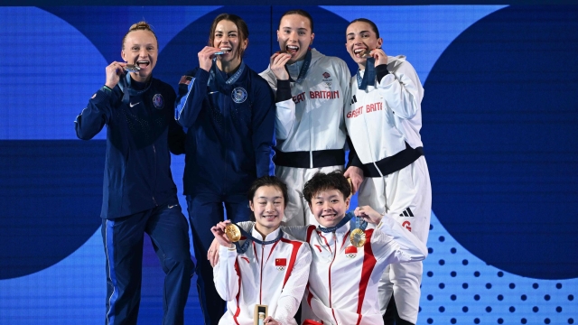 Silver medallists US' Kassidy Cook and Sarah Bacon (L), gold medallists China's Chang Yani and Chen Yiwen (C) and bronze medallists Britain's Scarlett Mew Jensen and Yasmin Harper (R) celebrate on the podium after the women's synchronised 3m springboard diving final at the Paris 2024 Olympic Games at the Aquatics Centre in Saint-Denis, north of Paris, on July 27, 2024. (Photo by SEBASTIEN BOZON / AFP)