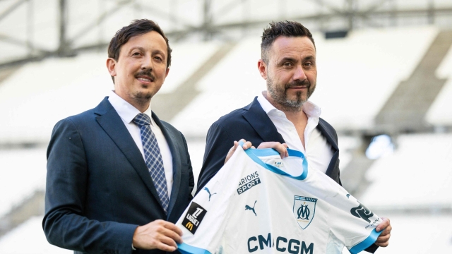 Marseille's Spanish President Pablo Longoria (L) and Marseille's newly recruited Italian head coach Roberto De Zerbi pose with a jersey after a press conference for his arrival at the Olympique de Marseille (OM) football club at the Velodrome Stadium in Marseille, southern France, on July 9, 2024. (Photo by CLEMENT MAHOUDEAU / AFP)