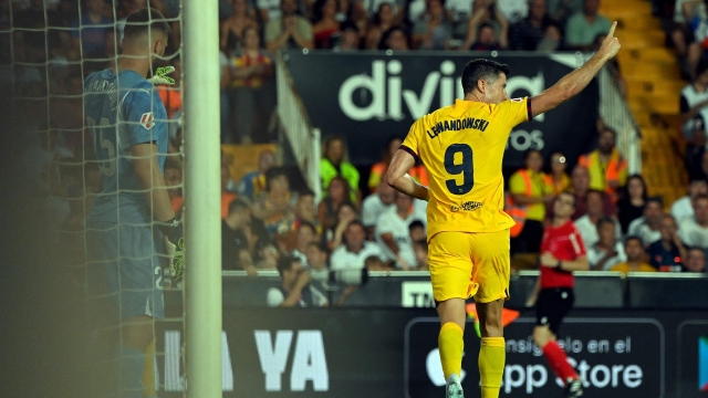 Barcelona's Polish forward #09 Robert Lewandowski celebrates scoring his team's first goal during the Spanish league football match between Valencia CF and Barcelona at the Mestalla stadium in Valencia on August 17, 2024. (Photo by JOSE JORDAN / AFP)