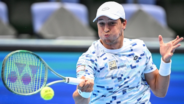 Italys Luciano Darderi hits a return to Argentina's Mariano Navone during their men's singles match at the Japan Open tennis tournament at Ariake Coliseum in Tokyo on September 25, 2024. (Photo by Yuichi YAMAZAKI / AFP)