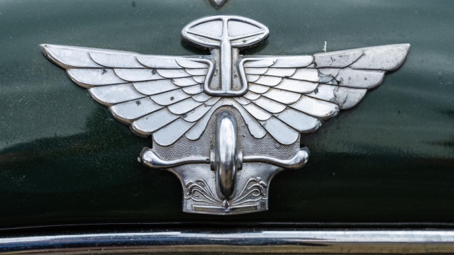  Vintage Austin hood ornament on a green car.