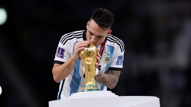  Lautaro Martinez of Argentina kisses the FIFA World Cup winning trophy during the award ceremony following the FIFA World Cup Qatar 2022 Final match between Argentina and France at Lusail Stadium on December 18, 2022 in Lusail City, Qatar. (Photo by Clive Brunskill/Getty Images)