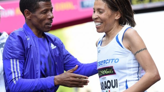 La maratonete Fatna Maraoui, terza classificata, fesetggiata da Haile Gebrselassie sul tragurado della Maratona di Milano, 12 aprile 2015. ANSA/DANIEL DAL ZENNARO