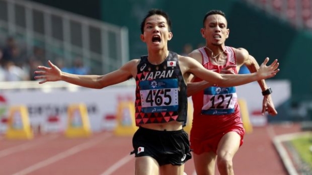 Il giapponese Hiroto Inoue precede Elhassan Elabbassi del Bahrein sul traguardo della maratona dei Giochi Asiatici a Giacarta