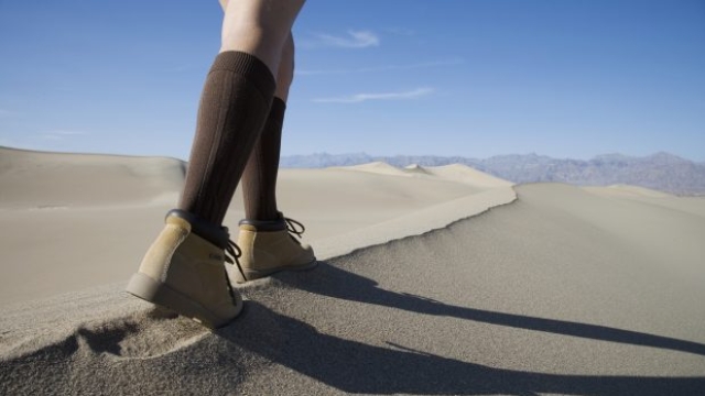 camminata - Woman walking on empty sand dunes, low section - Fotografo: gettyimages
