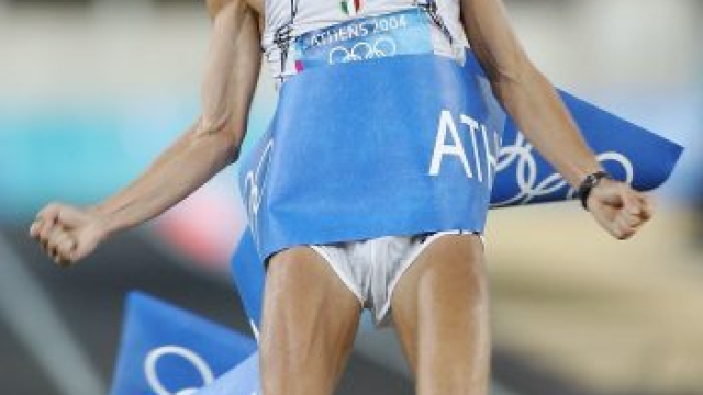 ATHENS - AUGUST 29: Stefano Baldini of Italy celebrates as he crosses the finish line first to win the gold medal in the men's marathon on August 29, 2004 during the Athens 2004 Summer Olympic Games at Panathinaiko Stadium in Athens, Greece. (Photo by Clive Mason/Getty Images)