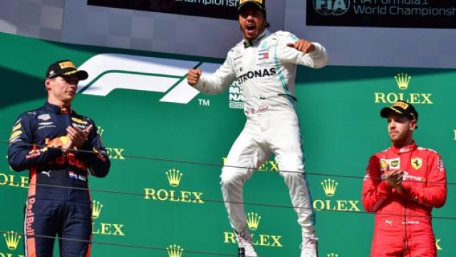 Hamilton esulta sul podio con Verstappen e Vettel. Afp