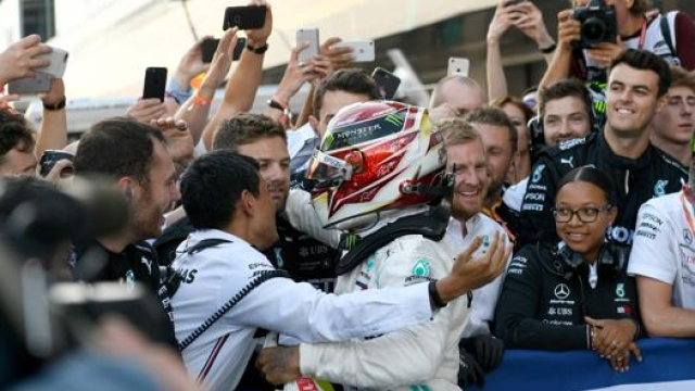 L’abbraccio tra Lewis Hamilton e i membri del team Mercedes. Afp