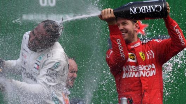 Sebastian Vettel (a des) sul podio con Lewis Hamilton. Afp
