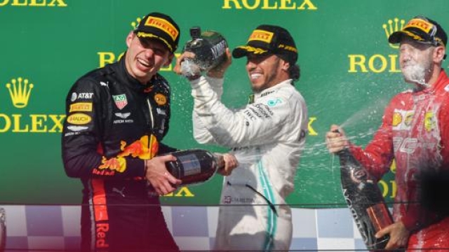 Hamilton festeggia Verstappen sul podio del GP di Ungheria. A destra Sebastian Vettel. Afp