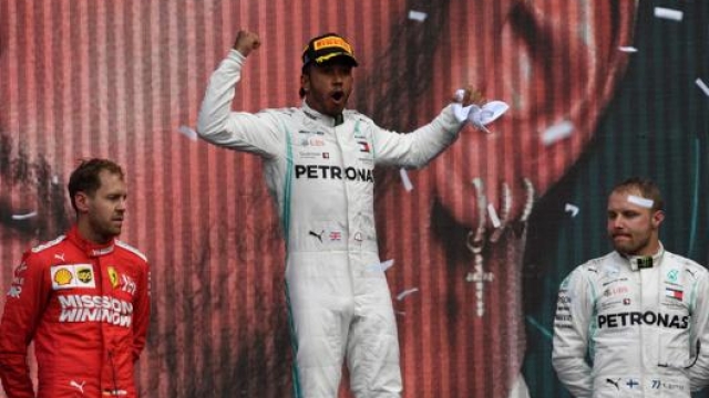 Lewis Hamilton esulta tra Vettel e Bottas. Afp