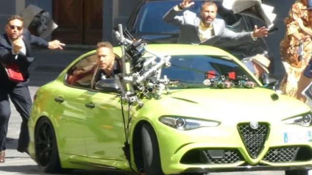 Ryan Reynolds seduto sul sedile del passeggero dell'Alfa Romeo Giulia Quadrifoglio, protagonista assoluta del film