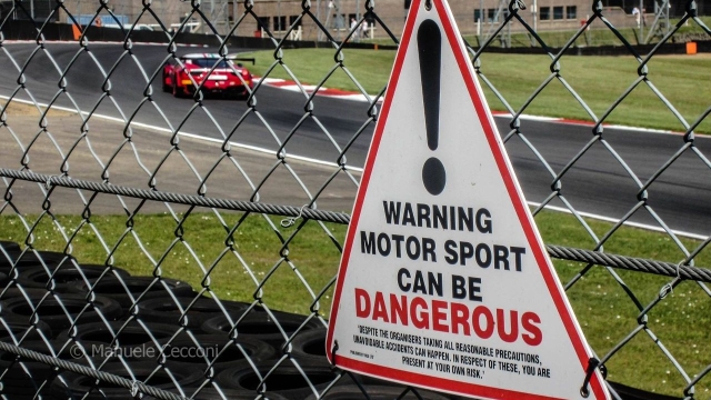 Motorsport can be dangerous: un cartello avverte del pericolo a Brands Hatch. Cecconi