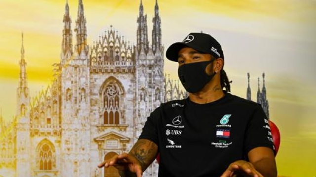 Lewis Hamilton, 35 anni, in total black davanti all’immagine del duomo di Milano. AFP