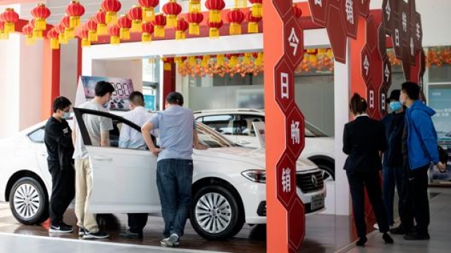 Potenziali clienti in visita a un concessionario di Pechino. Afp