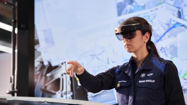 Un addetta alla produzione nello stabilimento Bmw di Monaco al lavoro sfruttando la tecnologia della realtà aumentata
